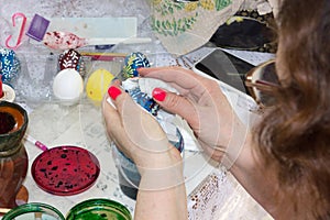 On Easter Eve, a woman paints an Easter egg