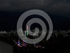 Easter Fair against a dull black and white gloomy landscape, Grenoble, 2023