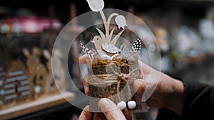 Easter fair. close-up. female hands holding a beautiful Easter decoration, composition with a bird, eggs and flowers