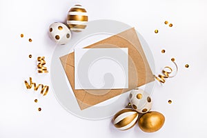 Easter festive decoration. Top view of easter eggs colored with golden paint in differen patterns and empty mock-up card in a kraf