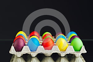Easter festive multicolor eggs carton, black background