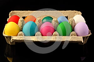 Easter festive multicolor eggs carton, black copy-space background