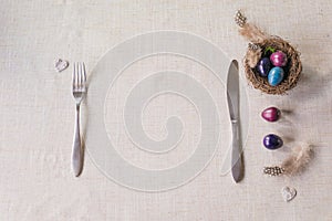 Easter festive spring table setting decoration, naturally dyed quail eggs in nest, selective focus