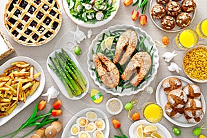 Easter festive table with salmon, asparagus, salad, potato, muffins and berry pie