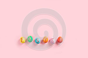 Easter flat lay composition with colorful painted natural eggs on pink background