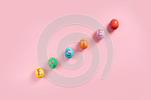 Easter flat lay composition with colorful painted natural eggs on pink background
