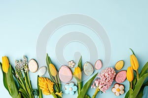 Easter floral background, various gingerbread glazed cookies end decorated with natural botanical elements on blue, flat lay, view