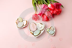 Easter floral background, various gingerbread glazed cookies end decorated with natural botanical elements on pink, flat lay, view