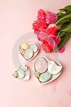 Easter floral background, various gingerbread glazed cookies end decorated with natural botanical elements on pink, flat lay, view