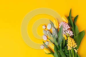 Easter floral background, various gingerbread glazed cookies end decorated with natural botanical elements on yellow, flat lay,