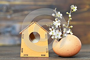 Easter flowers in eggshell and birdhouse