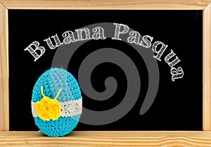 Easter frame with painted eggs and chalkboard. Happy Easter in white chalk. Happy Easter in italian : buana pasqua