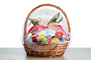 Easter gift basket with multicolor eggs, white background