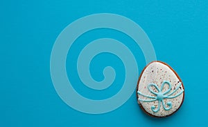 Easter ginger glazed cookies in the shape of an egg in a row. Easter holiday concept. Egg on a blue background with place for text