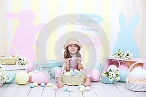 Easter! A girl holds a basket of eggs on the background of Easter interior. Easter colorful decor. Girl chasing Easter eggs. sprin