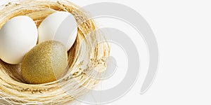 Easter golden and white eggs in straw nest on white background. Trendy bright egg for spring holiday. Sparkle Easter