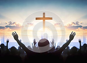 Easter and Good Friday concept, soft focus of Christian worship with raised hand on cross sunset background