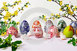 Easter graphic depicting Easter eggs, plants and chickens on a white background.