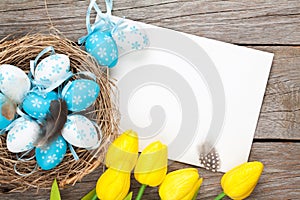 Easter greeting card with blue and white eggs and yellow tulips