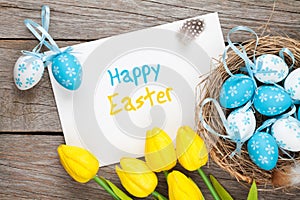 Easter greeting card with blue and white eggs and yellow tulips