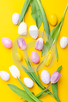 Easter greeting card. Multicolored easter eggs and tulips on yellow background. Easter concept