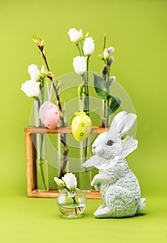 Easter greeting concept. Easter bunny and white spring flowers in vases