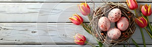 Easter Greetings: Pink Eggs and Yellow Tulips in Bird Nest Basket on White Wooden Table Background - Top View Flat Lay Banner