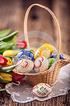 Easter. Hand made painted easter eggs in basket and spring tulips