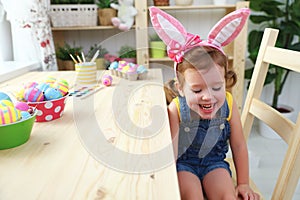 Easter. happy child girl with bunny ears with colored eggs and f