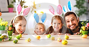 Easter. happy family mother father and children are preparing for holiday home with eggs