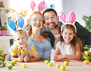 Easter. happy family mother father and children are preparing for holiday home with eggs