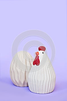 Easter henn and egg decoration objects on purple background with copy space