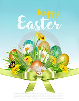 Easter Holiday Background with colofrul eggs in green grass and spring flowers.