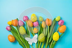 Easter holiday background with easter eggs and tulip flowers. Top view, flat lay