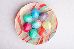 Easter holiday with colorful eggs on a plate while cooking. Homemade baking