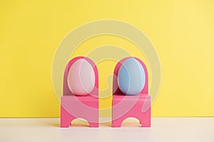 Easter holiday concept with cute eggs life. Different emotions and feelings. Lovely couple eggs sitting on pink chairs