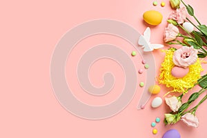 Easter holiday concept with easter eggs and spring flowers on pink background. Top view, flat lay