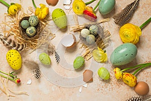 Easter holiday concept with easter eggs and spring flowers on stone background.