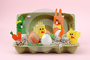 Easter holiday concept with eggs, cute handmade bunny, chicks in papaer box for egg, sptingtime background