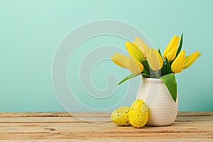 Easter holiday concept with tulip flowers and eggs decorations on wooden table