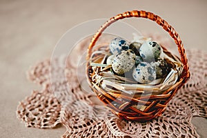 Easter holiday decoration. Quail eggs wrapped in hay in woven b