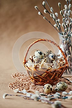 Easter holiday decoration. Quail eggs wrapped in hay in woven b