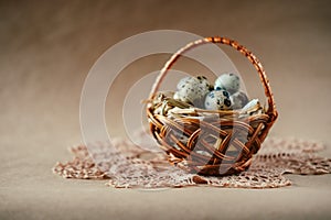 Easter holiday decoration. Quail eggs wrapped in hay in woven b