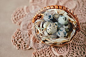 Easter holiday decoration. Quail eggs wrapped in hay in woven b