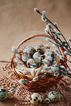 Easter holiday decoration. Quail eggs wrapped in hay in woven b