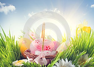 Easter holiday scene background. Traditional painted colorful eggs in spring grass over blue sky