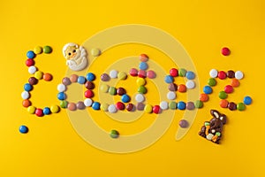 Easter inscription from colorful candies. Top view. Festive background. Food lettering