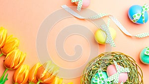 Easter message. Colorful egg with tape ribbon  spring tulips  feathers on pastel pink background in Happy Easter decoration. Foil