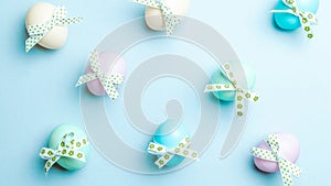Easter message. Colourful egg with tape ribbon on pastel blue background in Happy Easter decoration. Foil minimalist egg design,