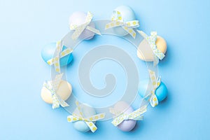 Easter message. Colourful egg with tape ribbon on pastel blue background in Happy Easter decoration. Foil minimalist egg design,